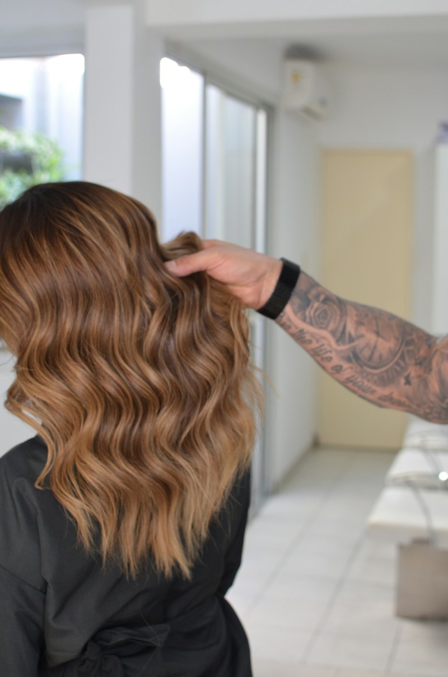 Long wavy hair with a caramel balayage, darker at the roots and golden through the lengths